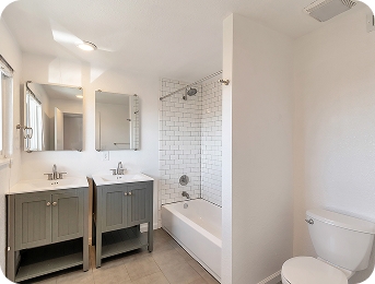 Full bathroom with double vanity and subway tile at Lime Apartments
