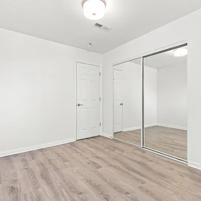 Primary bedroom with mirrored closet at Lime Apartments