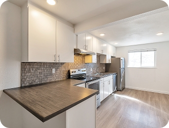 Kitchen with breakfast bar and mosaic backsplash at Lime Apartments